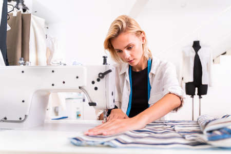 Fashion designer working in a clothing start-up workshop - Clothing tailor working on a new collectionの写真素材