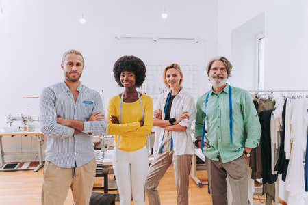 Multiethnic team of fashion designers working in a clothing start-up workshop - Multiracial group of stylists, tailor designers and dressmakers working on a new collectionの写真素材