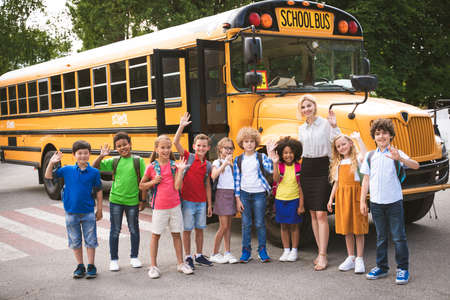Group of young students attending primary school on a yellow school bus - Elementary school kids ha1ving funの写真素材