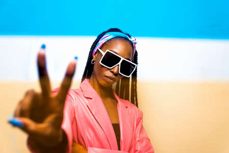 Beautiful afro-american woman with afro pigtails hairstyle and stylish clothes - Portrait of young black girl in studioの写真素材