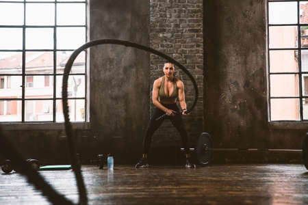 Beautiful woman training and making functional workout in the gymの写真素材