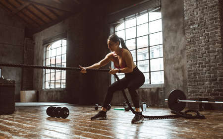 Beautiful woman training and making functional workout in the gymの写真素材
