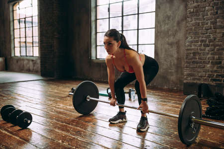 Beautiful woman training and making functional workout in the gymの写真素材