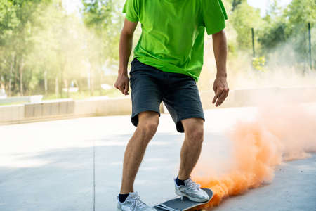 skaters with colored smoke bombs. Professional skateboarders having fun at the skate park