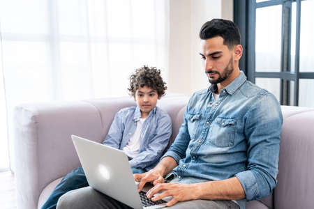 father and son spending time together at home. Arabian family lifestyle momentsの写真素材