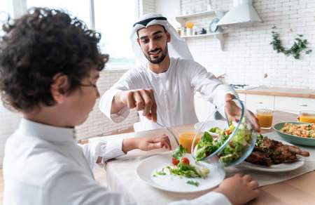happy family from arab united emirates eating together and celebrating the national day holidaysの写真素材