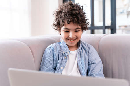 little kid studying on his laptop. Concept about childhood and technologyの写真素材