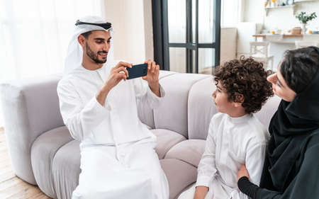 happy family spending time together. Arabian parents and their son playing and making different...