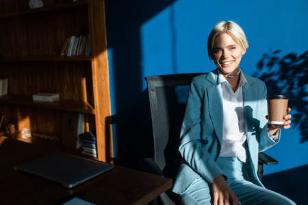 cinematic image of a young beautiful business woman. Portrait of an employee in his office