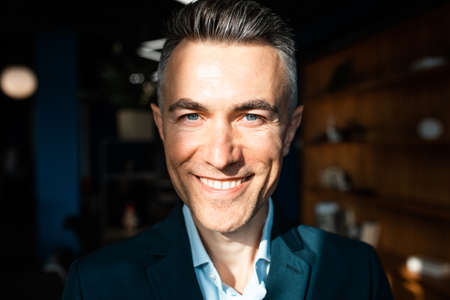 cinematic image of a senior handsome business man. Portrait of an employee in his office
