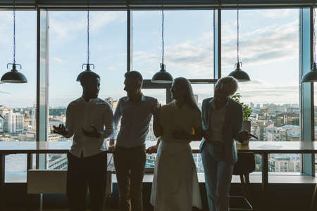 cinematic image of a multiethnic business team. employees speaking together on the balcony during the breakの写真素材