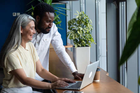 cinematic image of a multiethnic business team. Two employees working together on a project in the officeの写真素材