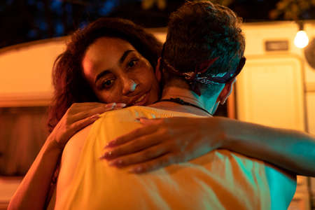 Young couple on vacation with the camper. Dancing outdoor in the night. Concept about wanderlust road trips and lifestyle on vacationの写真素材