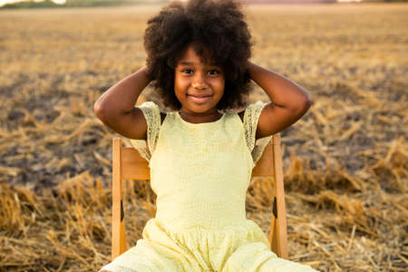 Pretty afro american girl in a sunflowers field having funの写真素材