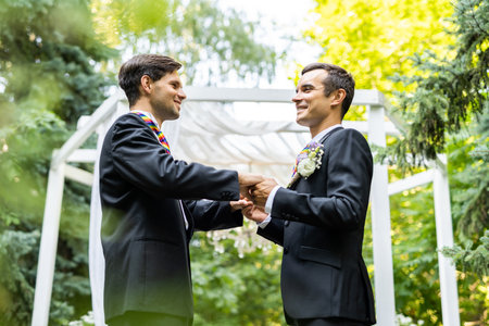Homosexual couple celebrating their own wedding - LBGT couple at wedding ceremony, concepts about inclusiveness, LGBTQ community and social equityの写真素材