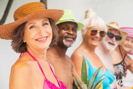 Happy seniors having party in the swimming pool - Elderly friends at a pool party during summertimeの写真素材