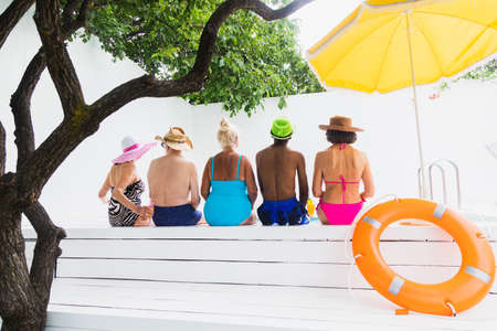 Happy seniors having party in the swimming pool - Elderly friends at a pool party during summertime