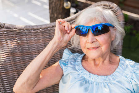 Beautiful senior woman relaxing at home in the garden - Pretty mature lady rests in a peaceful...