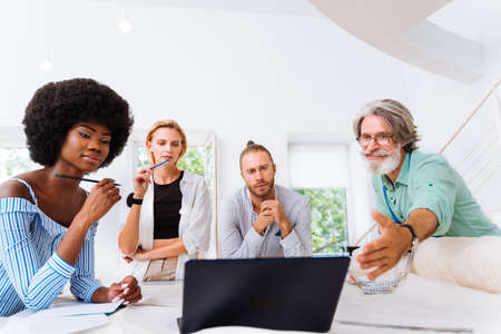 Multiethnic team of fashion designers working in a clothing start-up workshop - Multiracial group of...