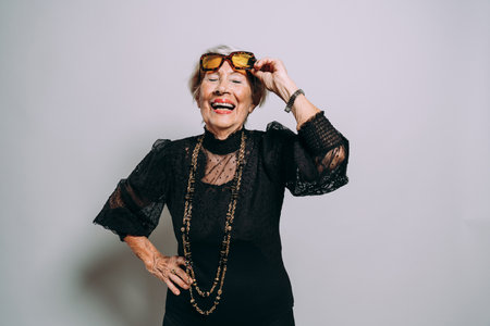 image of a beautiful and elegant old influencer woman. Cool grandmother posing in studio wearing fashionable clothesの写真素材