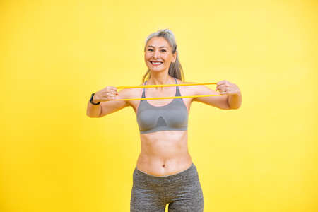 Beautiful middle aged woman making sport at the gym. Senior female model posing for a body positive...