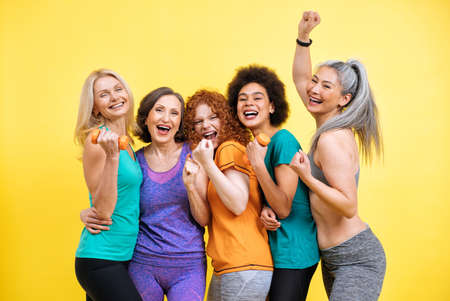 Group of women with different body, age, and ethnicity making sport. Female models wearing sport outfits having fun at the gym. Concept about body positivity, self acceptance and lifestyleの写真素材