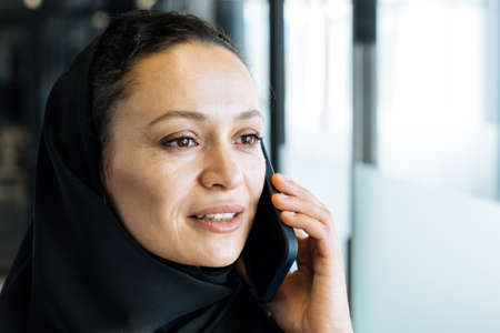 beautiful woman with abaya dress working and printing documents. Middle aged female employee at work...