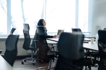 Beautiful woman with abaya dress working on her computer. Middle aged female employee at work in a business office in Dubai. Concept about middle eastern cultures and lifestyleの写真素材