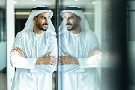 handsome man with dish dasha working in his business office of Dubai. Portraits of a successful...