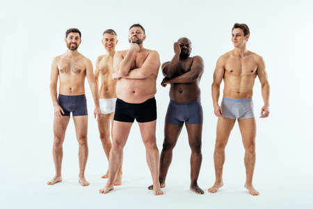 Group of multiethnic men posing for a male edition body positive beauty set. Shirtless guys with different age, and body wearing boxers underwearの写真素材