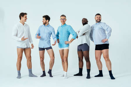 multiethnic men posing for a male edition body positive beauty set. guys with different age, and body wearing boxers underwear and shirtの写真素材