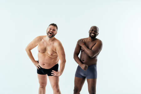 two multiethnic men posing for a male edition body positive beauty set. Shirtless guys with different age, and body wearing boxers underwearの写真素材