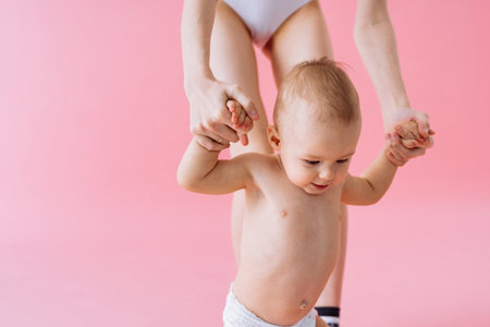 Happy woman holding her baby on colored background - Young woman wearing underwear taking care of her little son - Pregnancy, motherhood, people and expectation conceptの写真素材