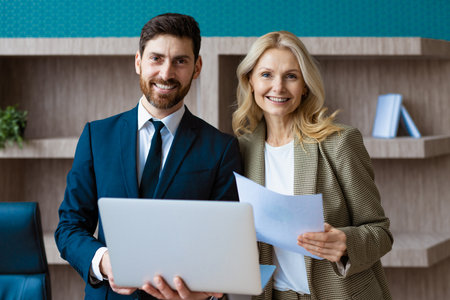 Businessman and mature businesswoman standing and talking about business projects - Diverse people...