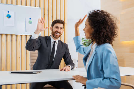 Businessman giving high five to her collegue in the office during brainstorming meeting for business projectの写真素材