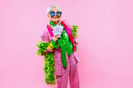 Happy and funny cool old lady with fashionable clothes portrait on colored background - Youthful...