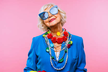 Happy and funny cool old lady with fashionable clothes portrait on colored background - Youthful grandmother with extravagant style, concepts about lifestyle, seniority and elderly peopleの写真素材