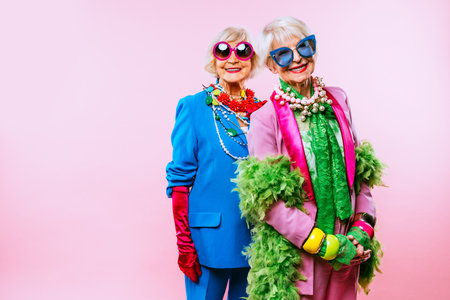 Happy and funny cool old ladies with fashionable clothes portrait on colored background - Youthful grandmothers with extravagant style, concepts about lifestyle, seniority and elderly peopleの写真素材