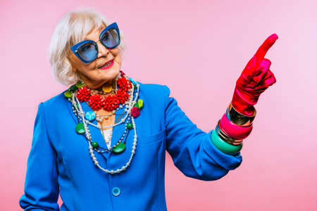 Happy and funny cool old lady with fashionable clothes portrait on colored background - Youthful...