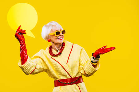 Happy and funny cool old lady with fashionable clothes portrait on colored background - Youthful...