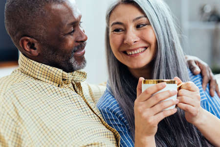 cinematic image of an happy multiethnic senior couple. Indoors Lifestyle moments at home. Concept...