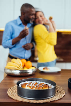 cinematic image of a multiethnic senior couple preparing food in the kitchen. Indoors Lifestyle...