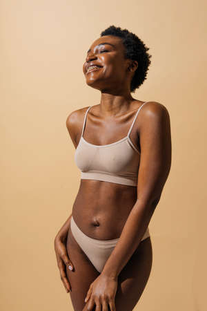 Beauty portrait of beautiful black woman wearing lingerie underwear - Pretty african young woman posing in studio, concepts about beauty, cosmetology and diversityの写真素材