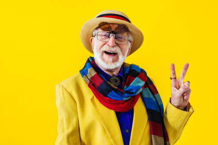 Cool senior man with fashionable clothing style portrait on colored background - Funny old male pensioner with eccentric style having funの写真素材
