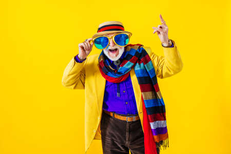Cool senior man with fashionable clothing style portrait on colored background - Funny old male pensioner with eccentric style having funの写真素材