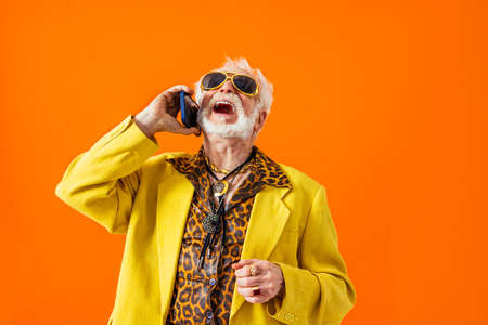 Cool senior man with fashionable clothing style portrait on colored background - Funny old male pensioner with eccentric style having funの写真素材