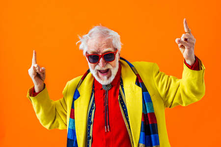 Cool senior man with fashionable clothing style portrait on colored background - Funny old male pensioner with eccentric style having funの写真素材