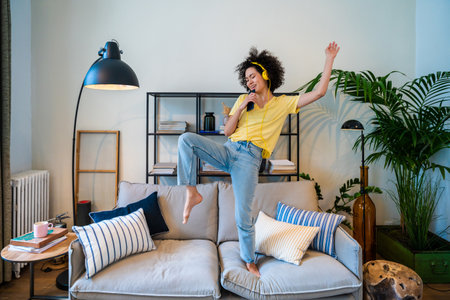 Beautiful latino young woman at home - Pretty south american with curly hair female portrait, lifestyle and domestic life sceneの写真素材