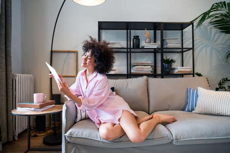 Beautiful latino young woman at home - Pretty south american with curly hair female portrait, lifestyle and domestic life sceneの写真素材