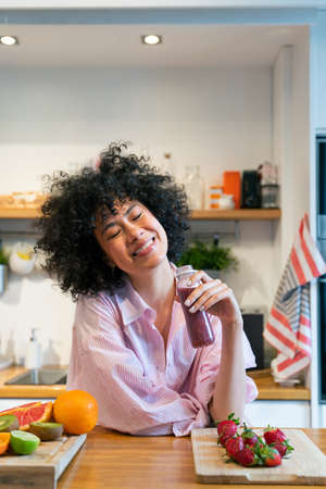 Beautiful latino young woman at home - Pretty south american with curly hair female portrait, lifestyle and domestic life sceneの写真素材